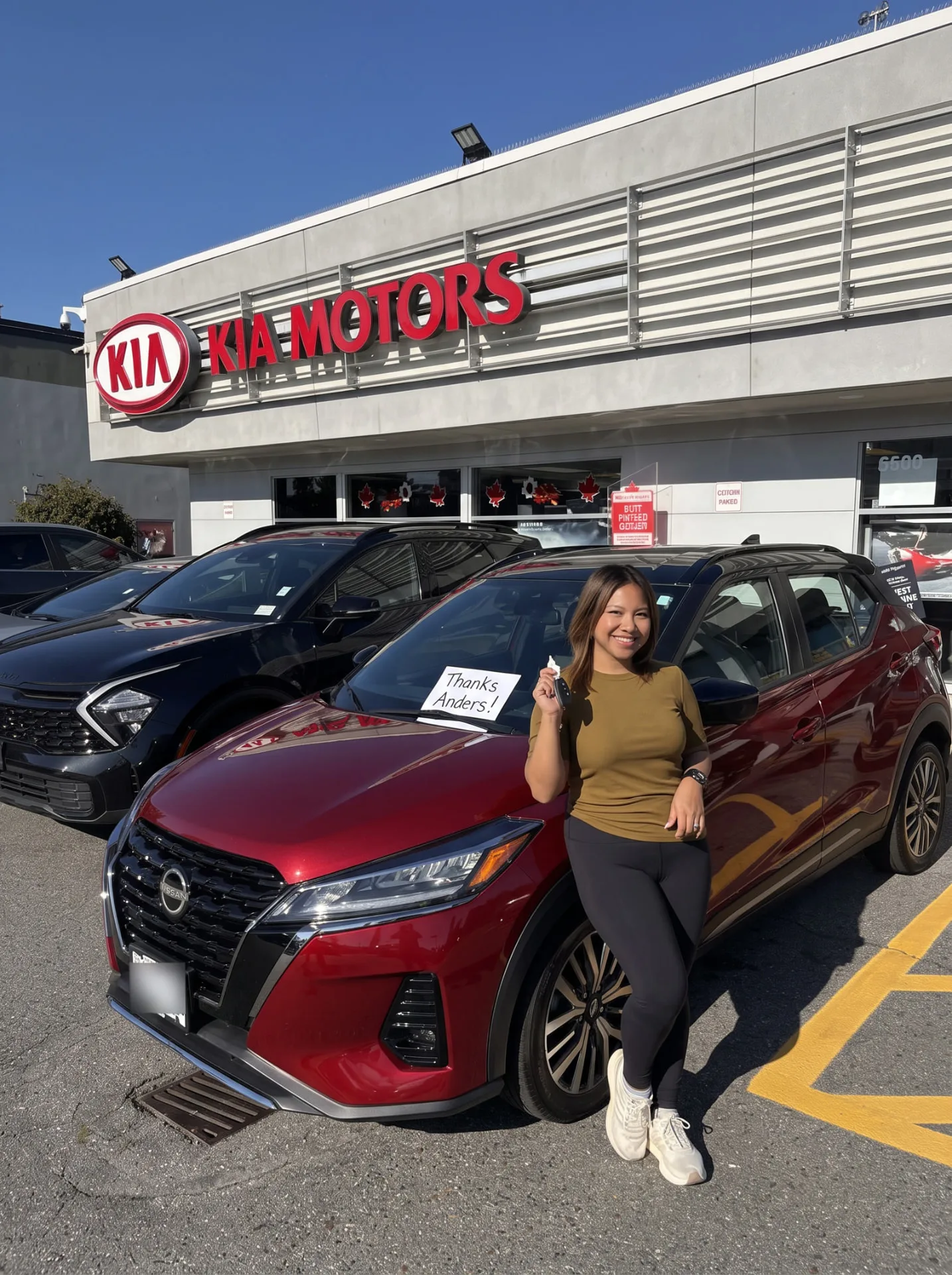 Woman with her red Nissan Kicks at the Kia store
