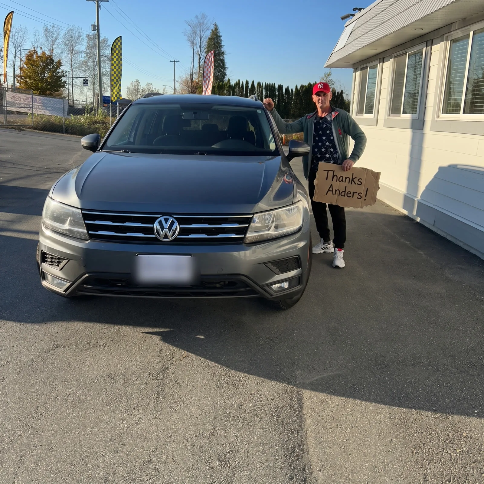 Man in a red cap with his grey VW Tiguan